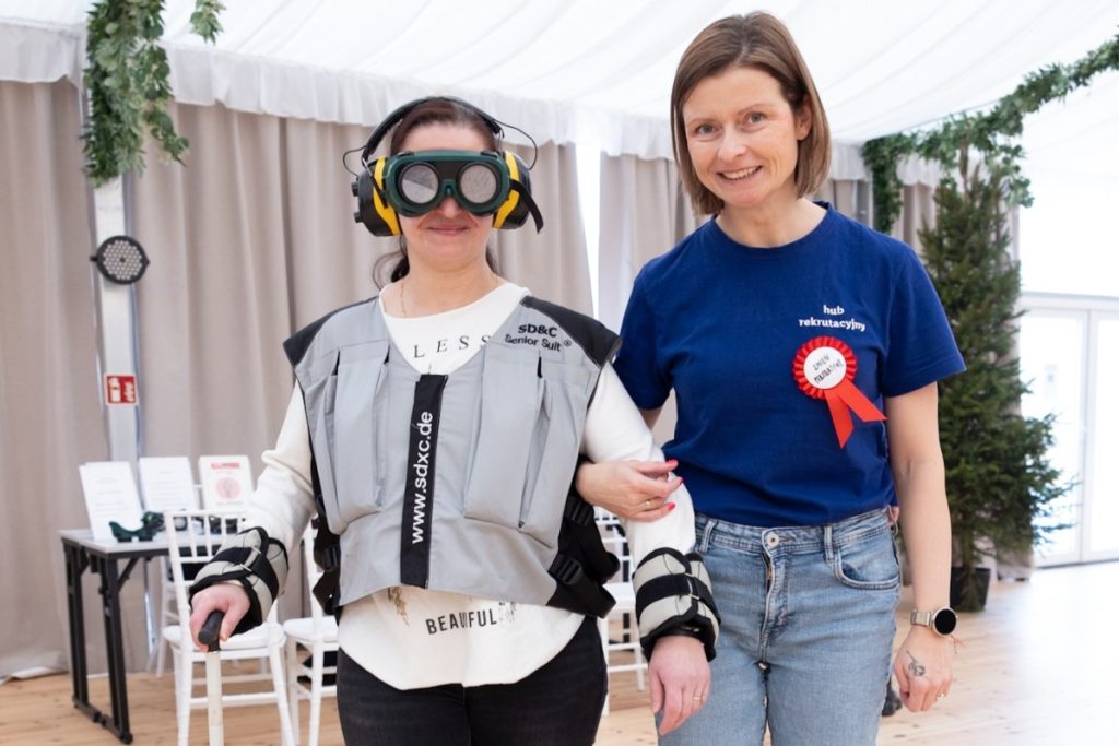 Workshop participant wearing simulation equipment to experience disability, supported by a facilitator during an inclusion training session as part of the Lidl Poland programme.